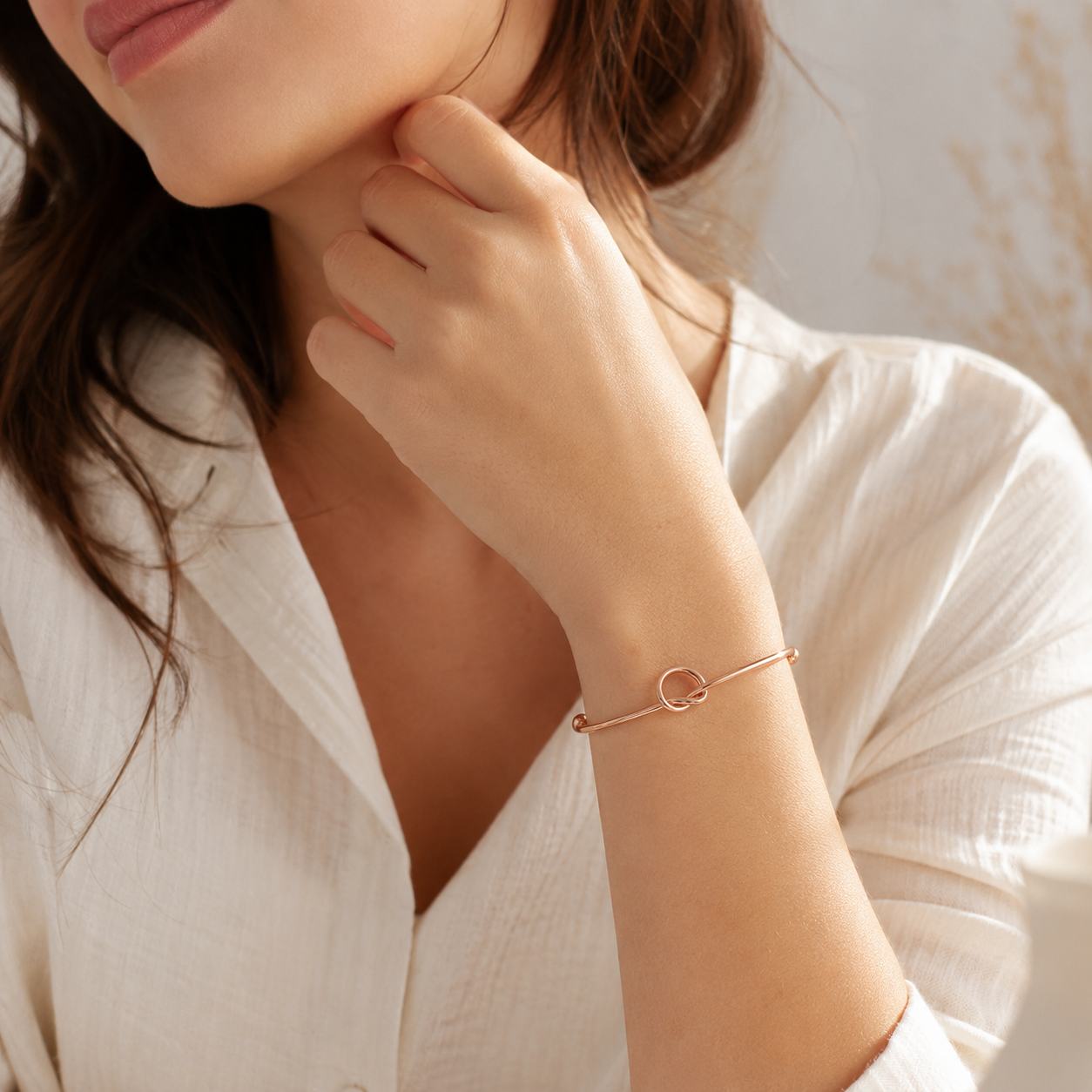 Close-up of a woman wearing a delicate bracelet on a soft background